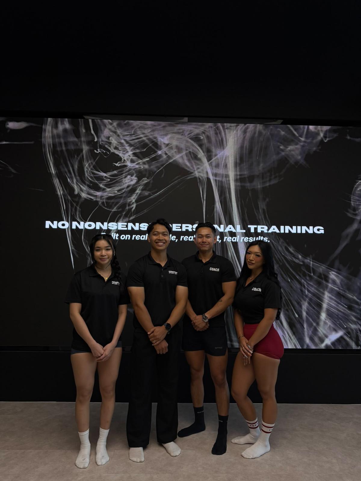 Four NNPT coaches together in front of the No Nonsense Personal Training backdrop